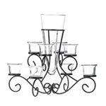 Dress up your table with dramatic beauty! The Scrollwork Candleholder with Vase is a stunning centerpiece that allows you to blend scrolling iron, candlelight, and fresh flowers into your décor. The tapered glass vase in the center is surrounded by six glass candle cups waiting to be filled.